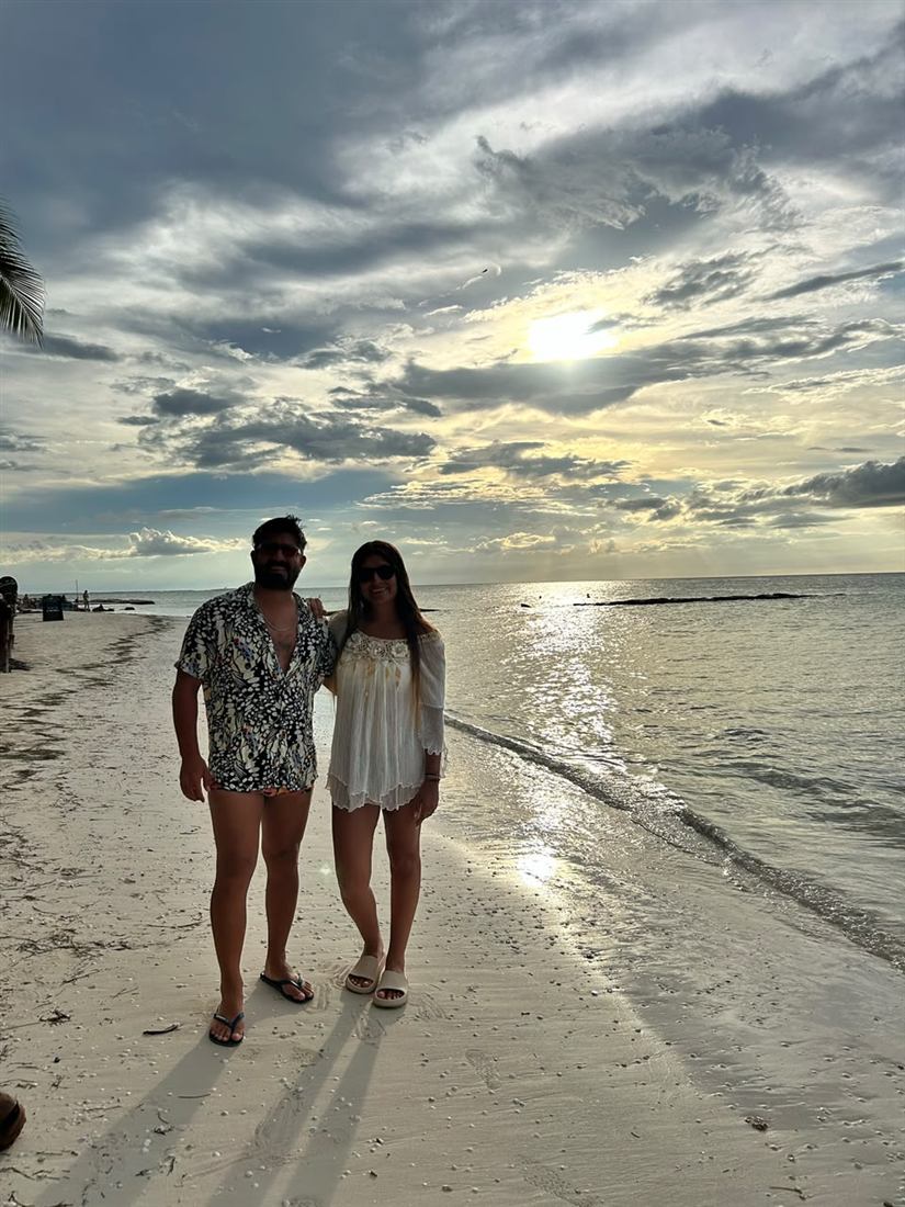 Leonel y su pareja en la orilla al atardecer